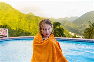 Caucasian girl wrapped in towel near swimming pool