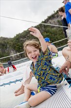 Caucasian boy waving arm on boat