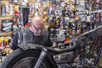 Caucasian man repairing motorcycle