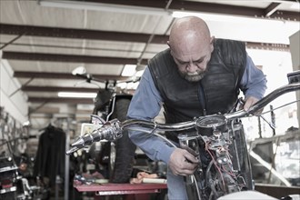 Caucasian man repairing motorcycle
