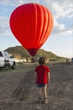 Caucasian boy watching distant hot air balloon