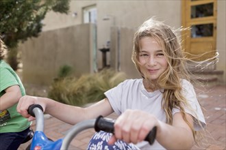 Wind blowing hair of Caucasian girl on bicycle