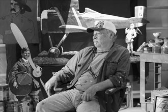 Portrait of older Caucasian man sitting in workshop