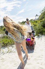 Wind blowing hair of Caucasian girl pulling brother in wagon