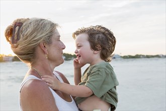 Caucasian mother holding boy at beach