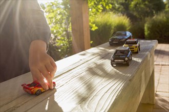 Sunshine on a Caucasian boy playing with toy cars