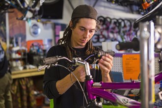 Man repairing bicycle in shop