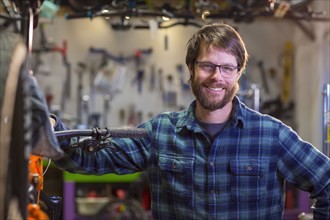 Portrait of smiling Caucasian man in bicycle shop