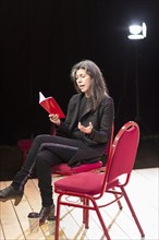 Hispanic woman reading script on theater stage