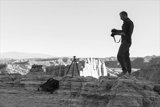 Caucasian photographer with tripod in desert
