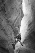 Caucasian man climbing rock formation