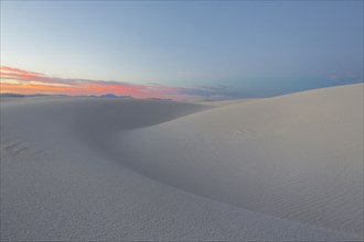 Sand dunes in desert at sunset