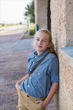 Confident Caucasian girl leaning on wall