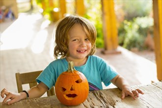 Portrait of smiling Caucasian boy with carved pumpkin