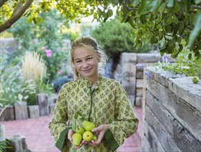 Portrait of smiling Caucasian girl holding pears