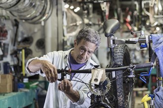 Caucasian man repairing brakes on bicycle