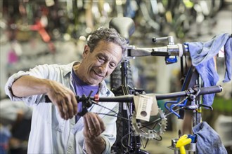 Caucasian man repairing brakes on bicycle