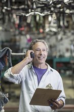 Caucasian man in bicycle shop talking on telephone