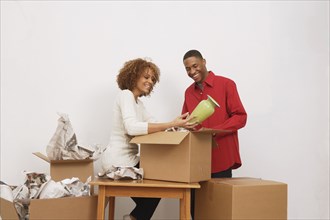 African couple unpacking moving boxes
