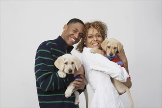 African couple holding puppies