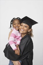 African female graduate holding daughter
