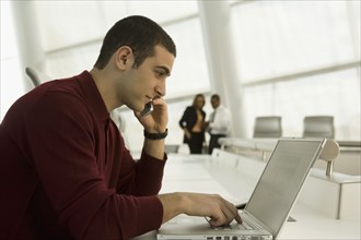 Mixed race businessman working on laptop