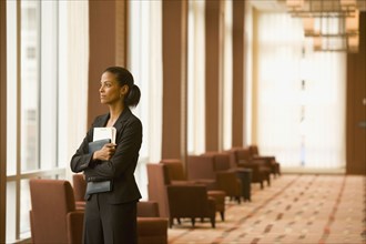 African businesswoman holding paperwork in hotel lobby