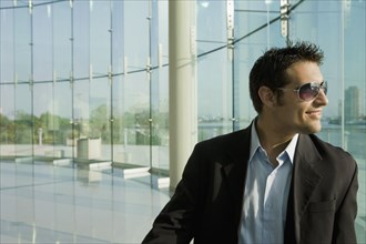 Mixed race businessman in glass walled room