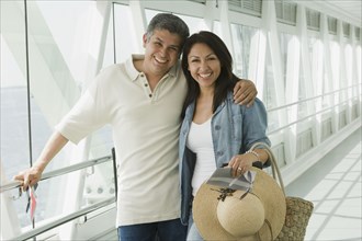 Hispanic couple standing in airport