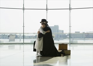 Hispanic father hugging daughter in airport
