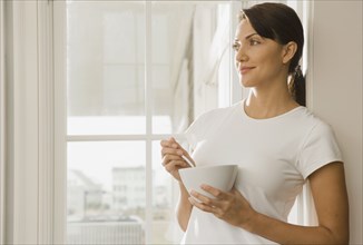 Hispanic woman eating from bowl