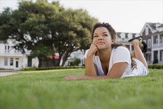 Mixed race woman laying on grass