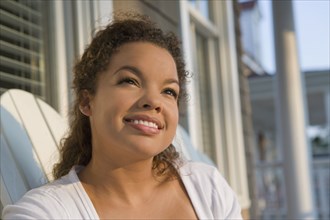 Mixed race woman sitting on porch