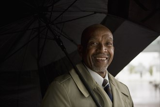 African businessman holding umbrella