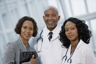 African businesswoman posing with doctors