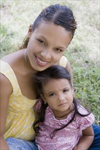 Hispanic woman sitting with daughter in lap
