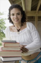 Hispanic woman standing with textbooks