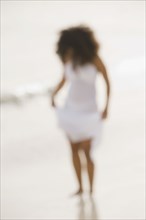 Defocused image of Hispanic woman at beach