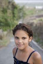 Hispanic girl standing in remote roadway