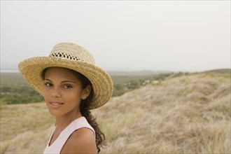 Hispanic girl in straw hat in remote field