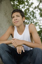 Hispanic teenage boy sitting outdoors