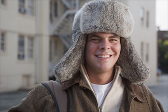 Mixed race man wearing fur hat