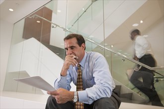 Businessman reviewing paperwork in office lobby