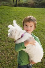 Mixed race boy holding small dog