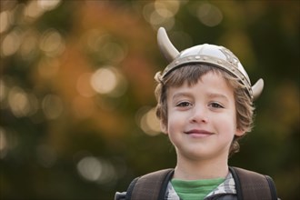 Mixed race boy in viking hat outdoors