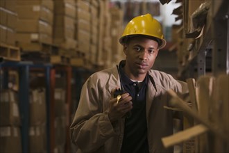 Black man with walkie-talkie working in warehouse