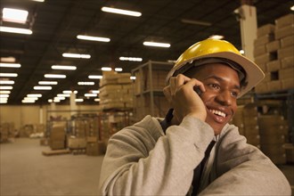 Black man talking on cell phone in warehouse