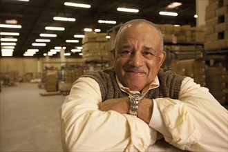 Mixed race man with arms crossed in warehouse