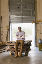 Black man sitting on pallets in warehouse