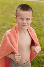 Caucasian boy wrapped in towel